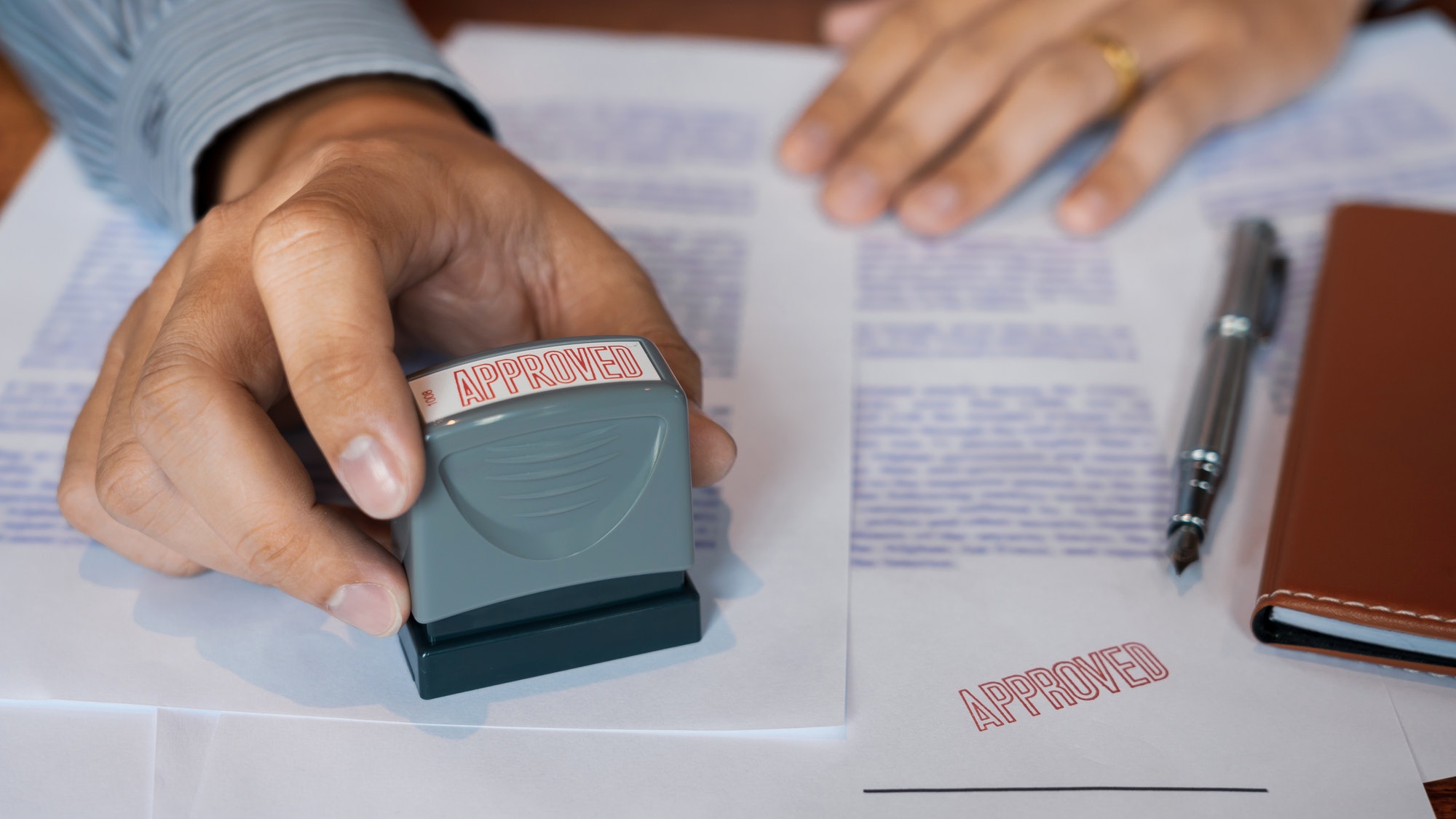 businessman Hand notary public hand ink appoval stamper Stamping seal On Approved Contract Form